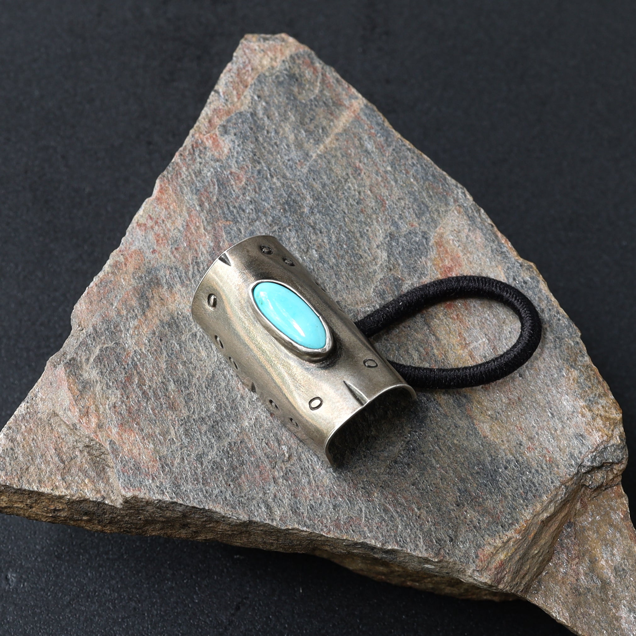 Flowers in her hair tie, sterling silver band with turquoise pendant.