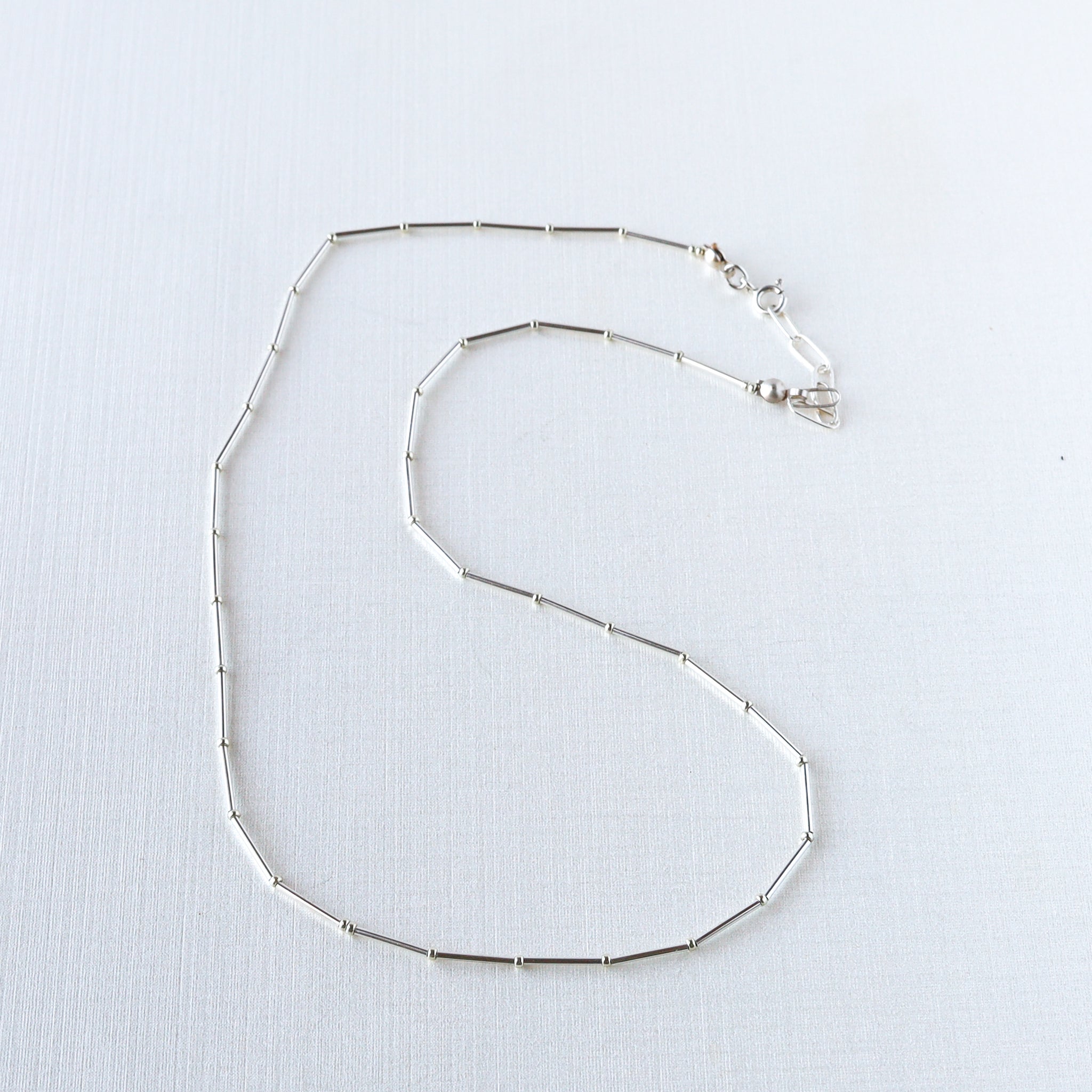 Rhythms Necklace, vintage brass beads in segments on silk cord with 14K gold-filled extender. Choose length and metal. This necklace is great layered or on its own. Sterling pictured